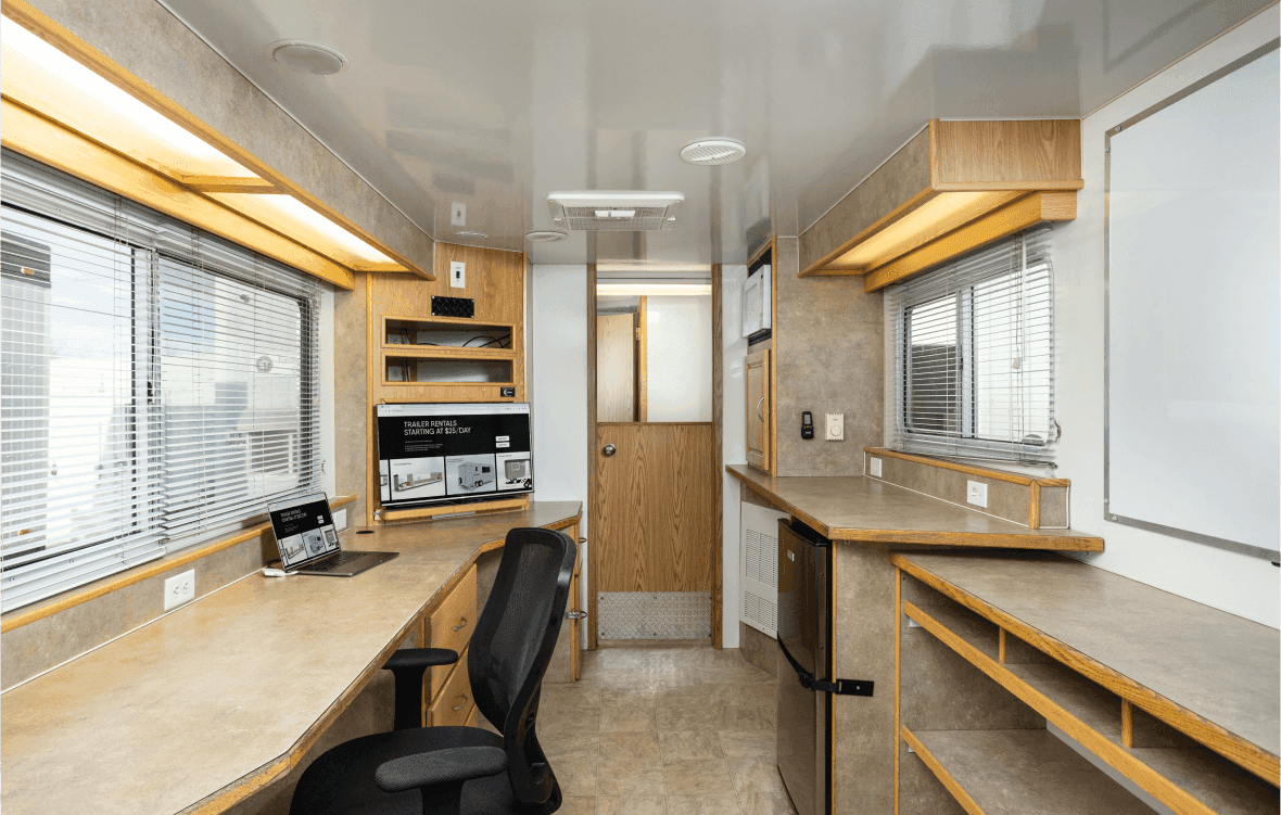 Interior of an optimized office trailer workspace with desk and equipment Interior of an optimized office trailer workspace with desk and equipment