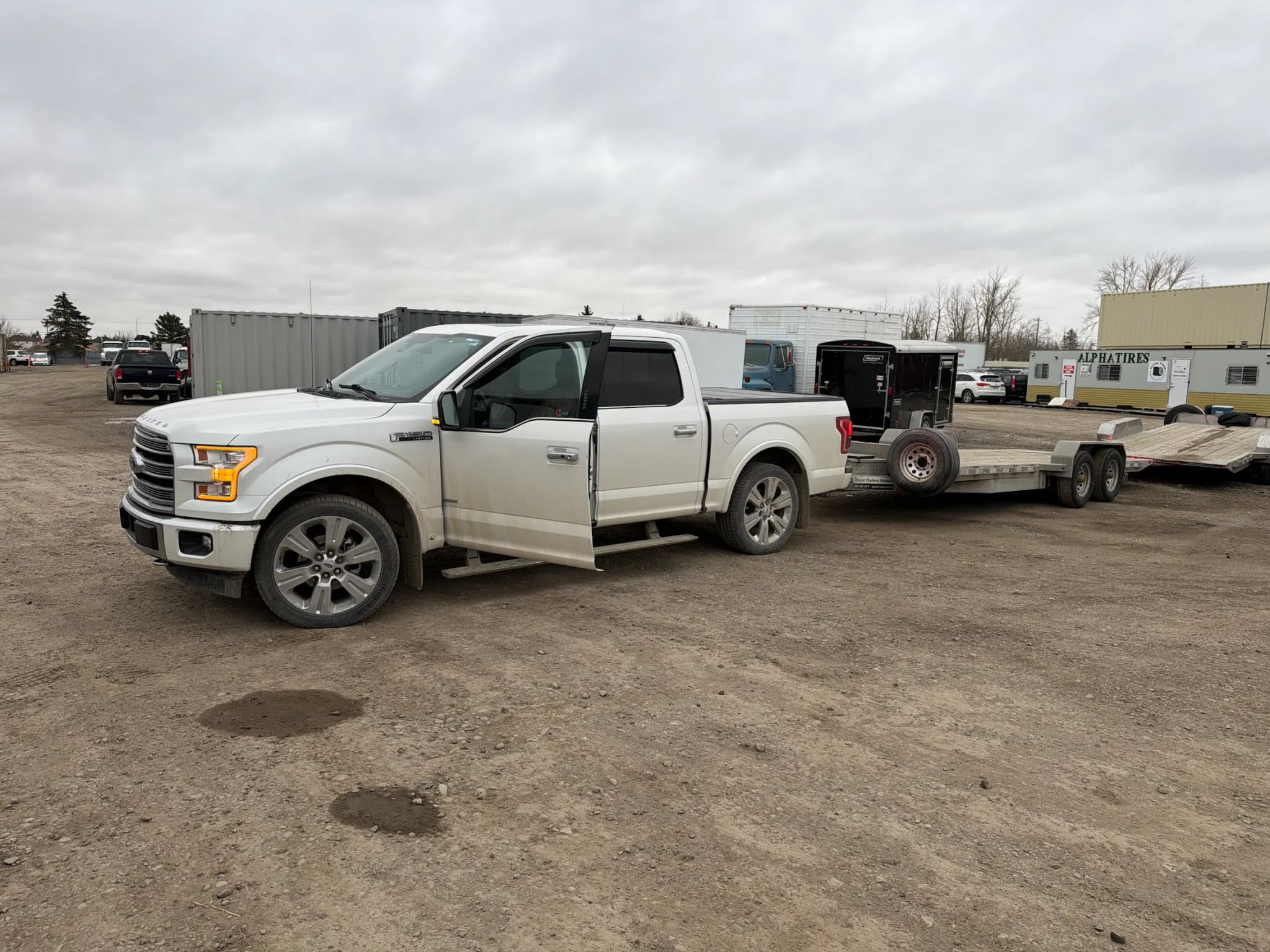 Client flat deck trailer hitched to a white pickup truck in Calgary