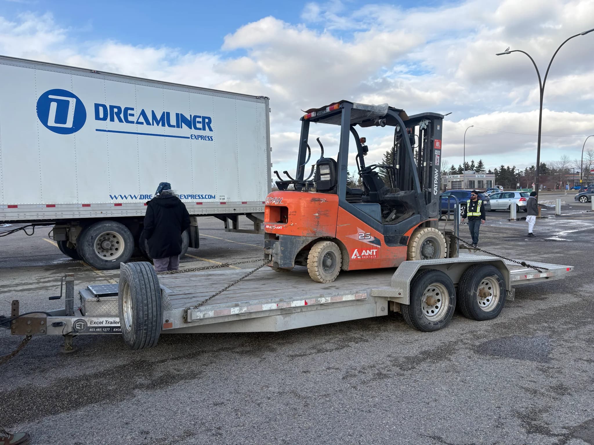 Flat deck trailer carrying a forklift in Calgary