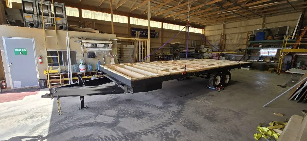 Office trailer steel frame on tandem axles with wooden floor joists set into the perimeter