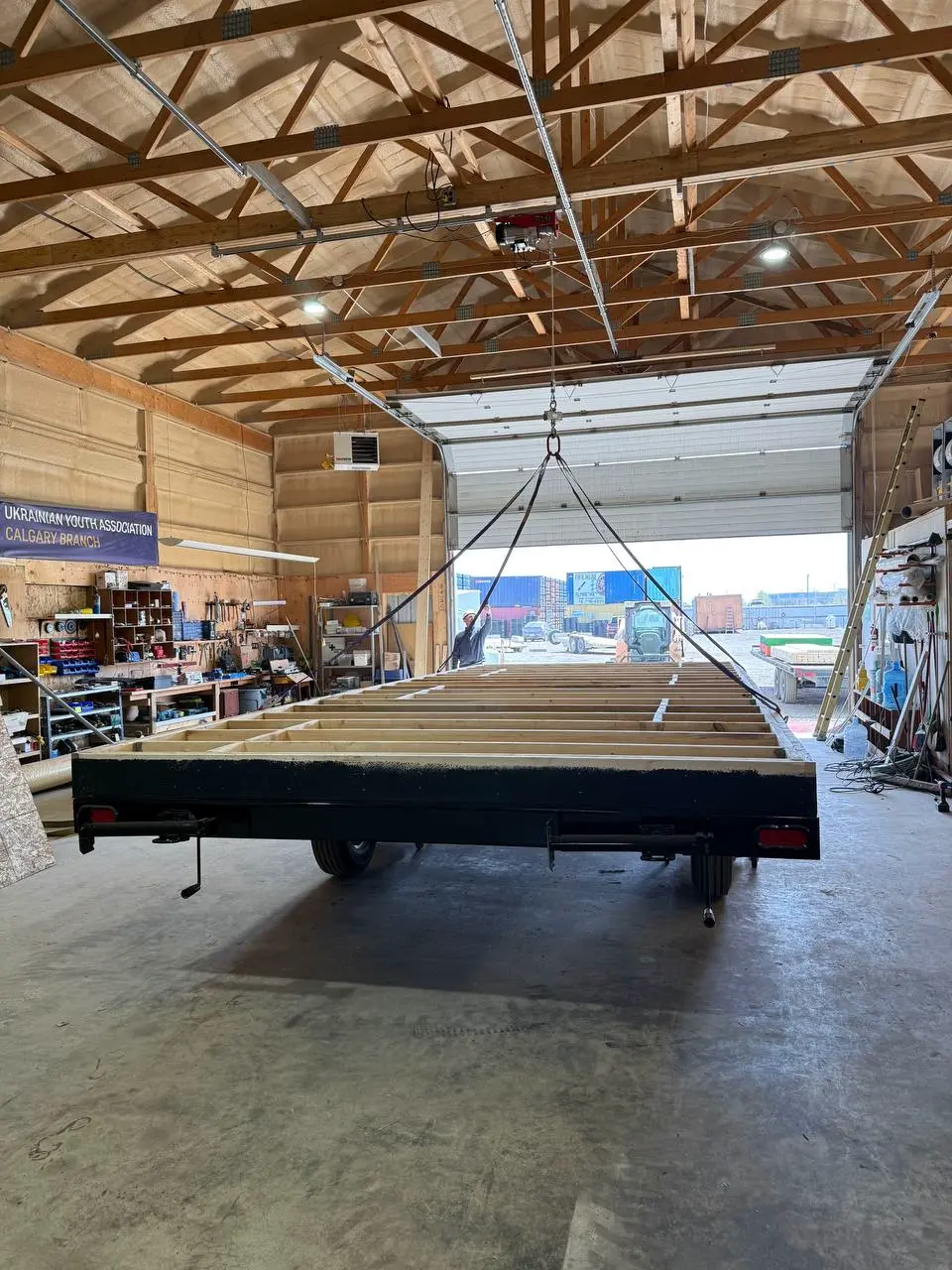 Office trailer floor frame under the overhead gantry inside the Excel Trailers Calgary shop