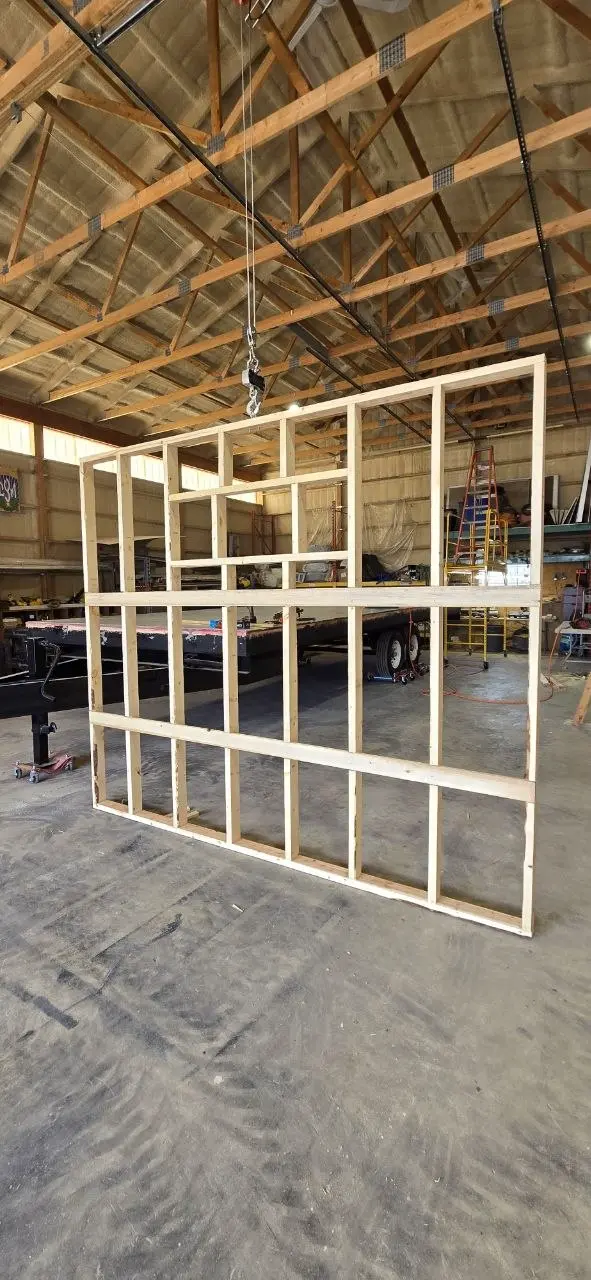 Interior partition wall frame with framed openings, lifted by the shop gantry