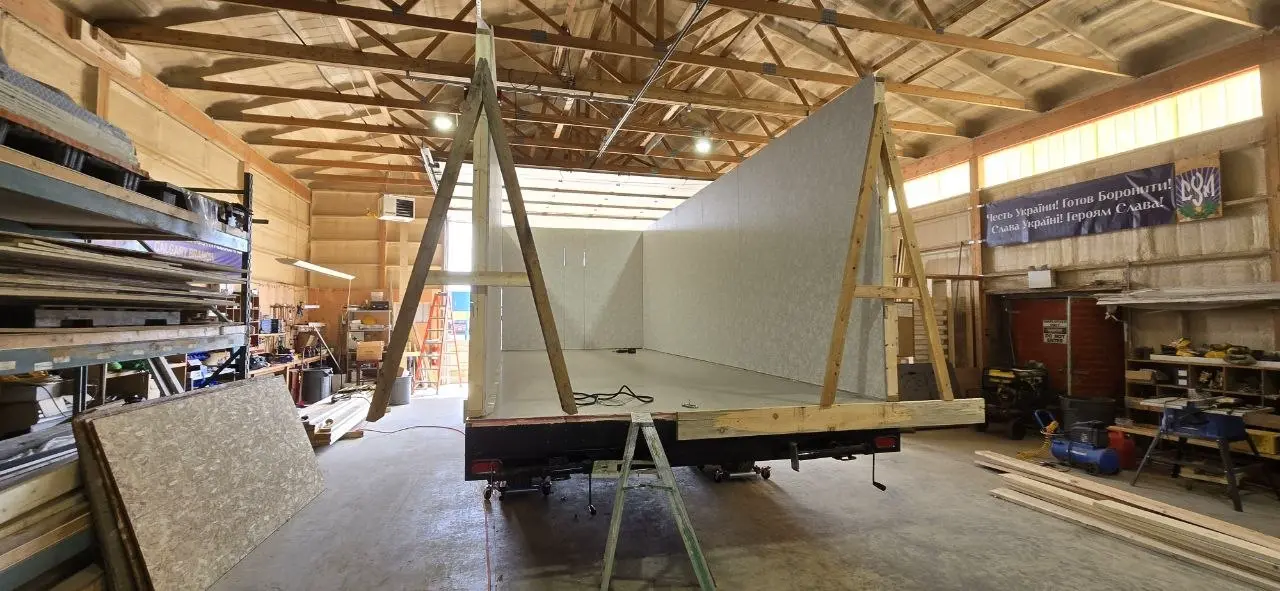 Both long walls of a new office trailer standing on the deck in the Excel Trailers shop