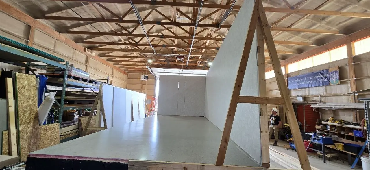 Interior view down a new office trailer with walls standing and the floor deck exposed